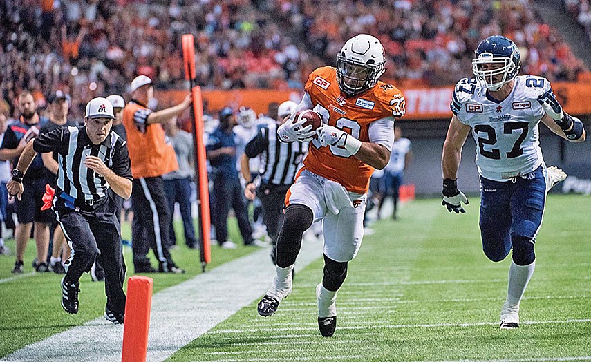 North Vancouver’s Dave Hawkshaw (left, in stripes) follows the action as Andrew Harris of the BC Lions heads to the end zone. Hawkshaw will be throwing flags in the NFL this year, moving down south after 14 seasons in the CFL. photos supplied