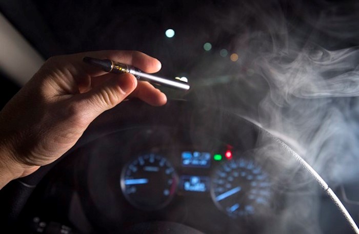 In this photo illustration, smoke from a cannabis oil vaporizer is seen as the driver is behind the