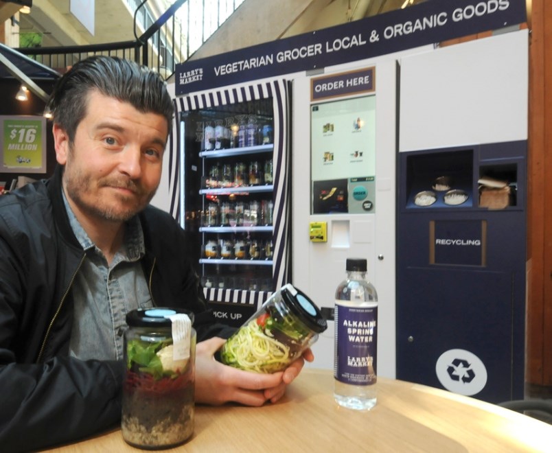 Owner Ryan Dennis displays some of the options available at the Larry's Market Express vending machi
