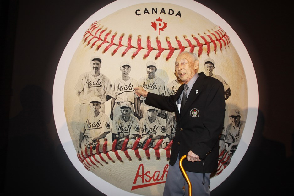Kaye Kaminishi pointing to his photo on the stamp unveiled Wednesday night in Burnaby. CONTRIBUTED