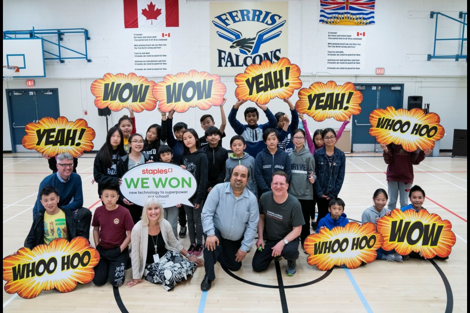 Dianne Steele, Principal of Ferris Elementary School in Richmond, BC , along with Staples General Manager Kuljinder Karwal and teacher Kevin Lyseng pose with some students for a photo after winning the Staples Superpower Your School Award.