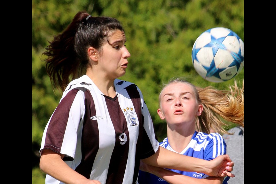 MARIO BARTEL/THE TRI-CITY NEWS Dr. Charles Best midfielder Eliana Arapi battles for control of a header with Centennial's Emily Smith in the first half of their Fraser Valley North girls senior high school soccer match, Monday at Best's turf field. The match ended in a 1-1 draw, clinching first place in the division for the Bue Devils.