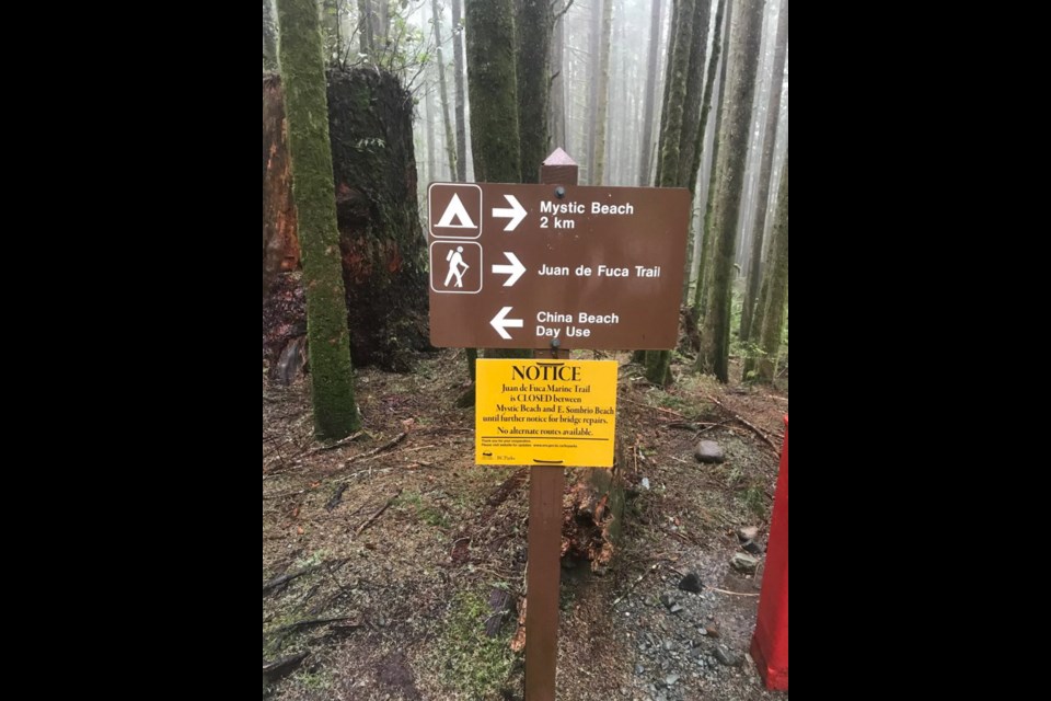 A sign advises hikers the Juan de Fuca trail is closed. The problem is a set of stairs that needs to be rebuilt in an exposed cliff area where no detour is possible.