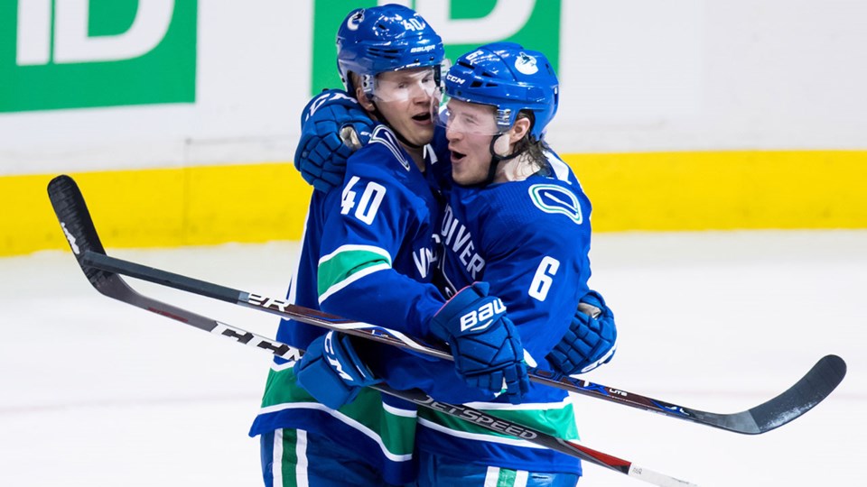 Elias Pettersson and Brock Boeser celebrate a goal for the Vancouver Canucks.
