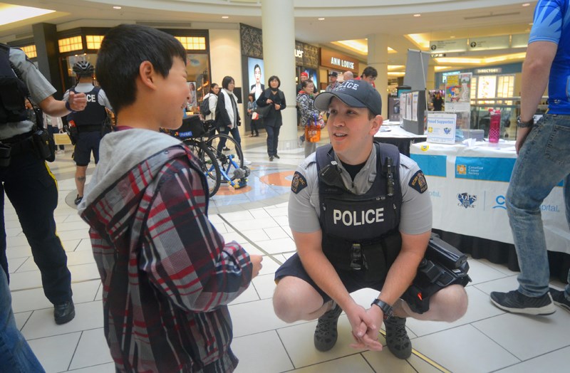 Burnaby RCMP Const. Jonathan Miville talks to a youngster checking out the jail-and-bail event at the Metrotown mall Friday.