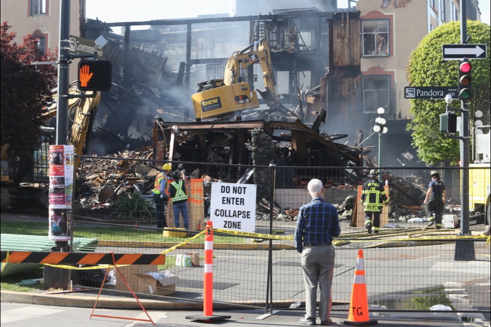 An excavator gets to work tearing down the walls of the burned out Plaza Hotel in downtown Victoria on Wednesday, May 8, 2019.