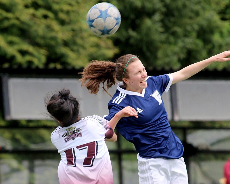 MARIO BARTEL/THE TRI-CITY NEWS Marina Verones, of the Dr. Charles Best Blue Devils, battles an Enver Creek defender for control of a header in the first half of their match in the Fraser Valleys, Monday at Best. Verones scored two goals to lead the Blue Devils to a 4-0 victory and stay alive in their hunt for a berth in the provincial AAA senior girls soccer championships to be played later this month in Cloverdale.