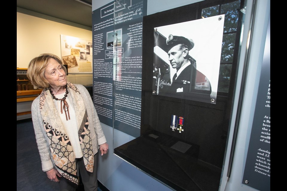 Ted Simmons' daughter, Deborah Cotton, looks at a display from Hero Warship: HMCS Beacon Hill and Her Daring Commander at the CFB Esquimalt Naval and Military Museum.