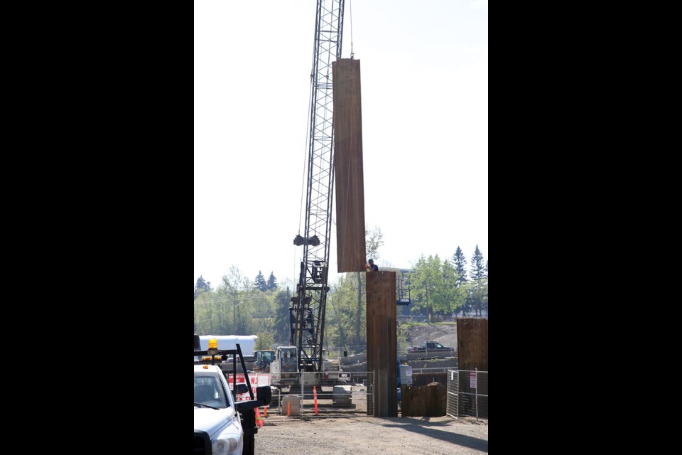 Workers use a crane to place large pieces of metal at the construction site of the Park House condominium development on Monday morning. Citizen Photo by James Doyle