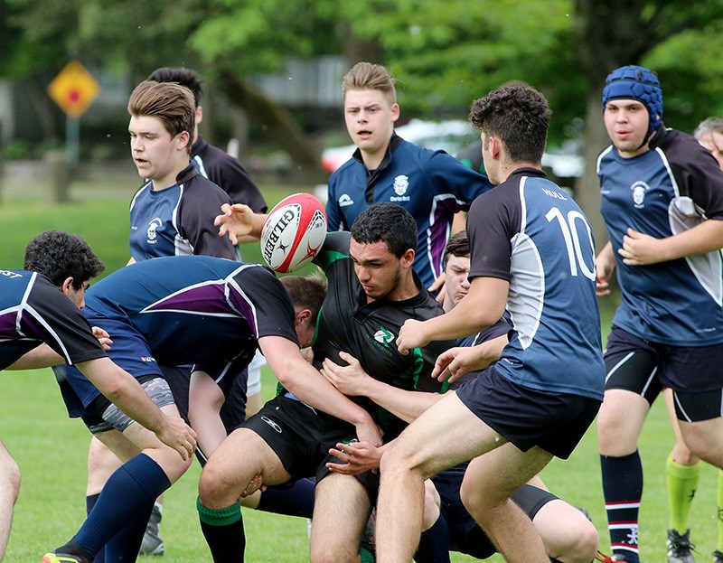 MARIO BARTEL/THE TRI-CITY NEWS Mo Hussein, of the Riverside Rapids, is swarm-tackled by Dr.Charles Best Blue Devils defenders in their BC High School AAA Tier 2 rugby playoff match last Thursday at Gates Park in Port Coquitlam. Riverside won, 42-15, and will play Southridge secondary in a semi-final Thursday in White Rock. The Terry Fox Ravens will host Fleetwood secondary in the other semi-final, after they defeated the Gleneagle Talons 78-0.