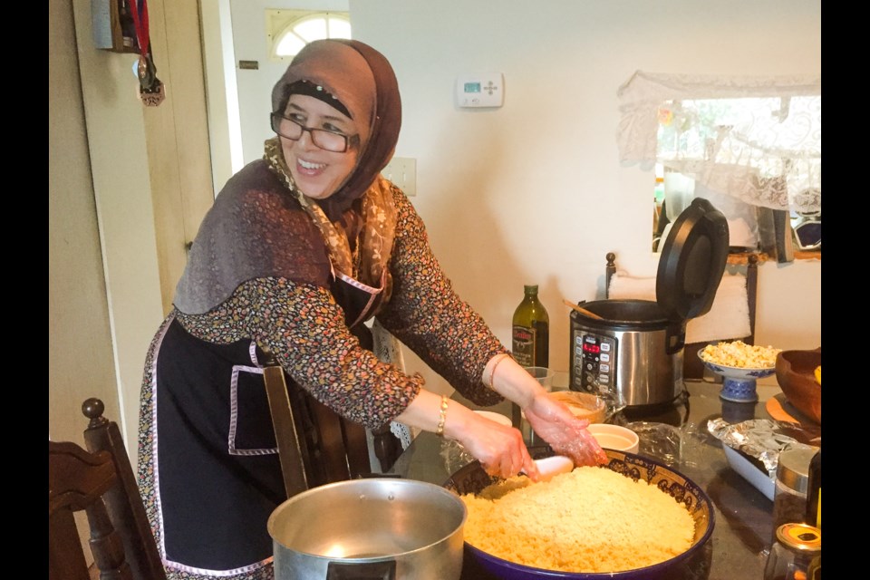 Malika Mahsoune fluffs up couscous, an important staple that requires a soft touch to give it a light texture and remove any lumps