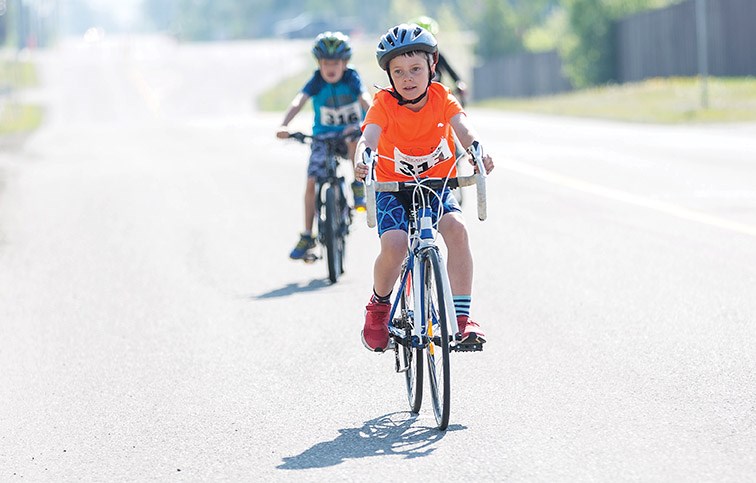 Levi Wilkinson pedals down 18th Avenue near Prince George Aquatic Centre on Sunday morning while competing in the 25th Annual Integris Credit Union Kids of Steel Triathlon. Citizen Photo by James Doyle