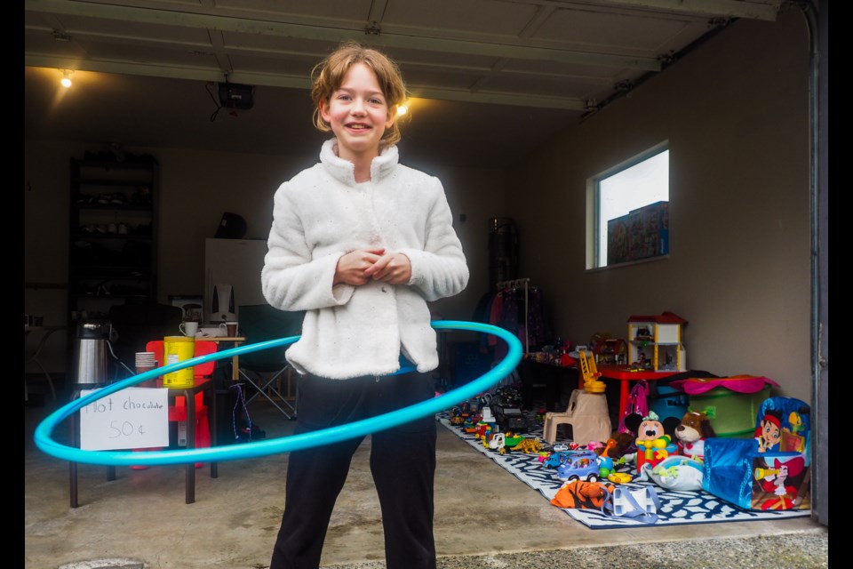 Sarah Barber, 11, waits for customers during the city-wide garage sale in Coquitlam Saturday, May 25