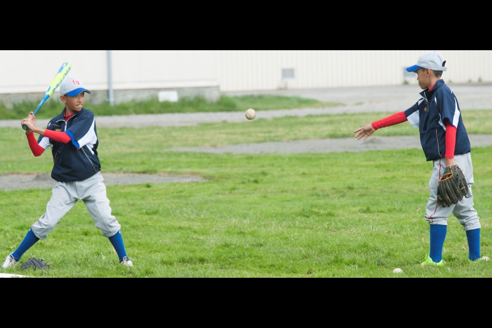 Fuyuan Baseball Academy players get in a little practice at Palmer on Saturday after rain wiped out its scheduled game against the Richmond Chuckers at the John Main Invitational. The Taiwan visitors went on to capture the 16-team event.