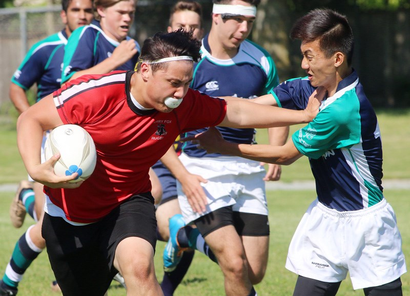 MARIO BARTEL/THE TRI-CITY NEWS Terry Fox Ravens inside centre Ethan Shuen tries to break away from a Fleetwood defender in their Fraser Valley AAA/Tier2 boys rugby semi-final last Thursday at Fox. The Ravens won, 66-7, and will face crosstown rivals, Riverside Rapids, in this Thursday's final.