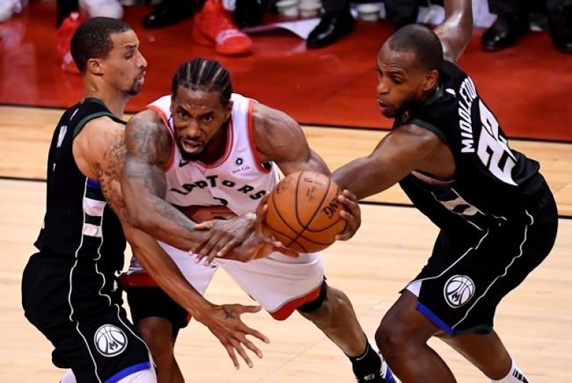 Toronto Raptors forward Kawhi Leonard gets bound up by Milwaukee Bucks guard George Hill and teammate Khris Middleton during second half NBA Eastern Conference finals action in Toronto on Saturday, May 25, 2019. photo THE CANADIAN PRESS/Frank Gunn