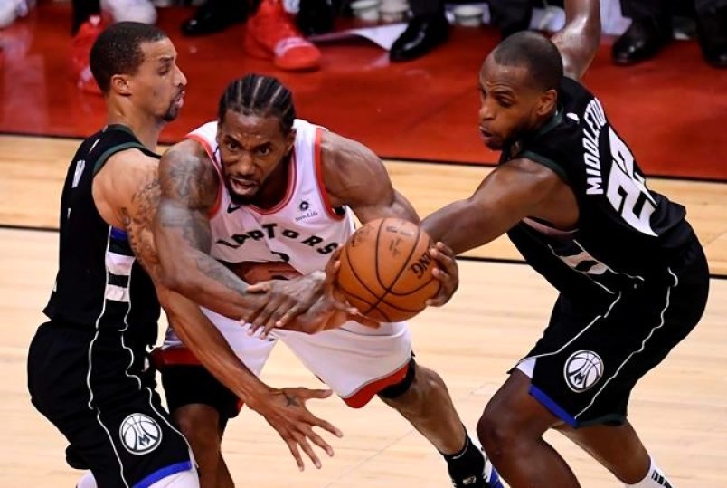Toronto Raptors forward Kawhi Leonard gets bound up by Milwaukee Bucks guard George Hill and teammate Khris Middleton during second half NBA Eastern Conference finals action in Toronto on Saturday, May 25, 2019. photo THE CANADIAN PRESS/Frank Gunn