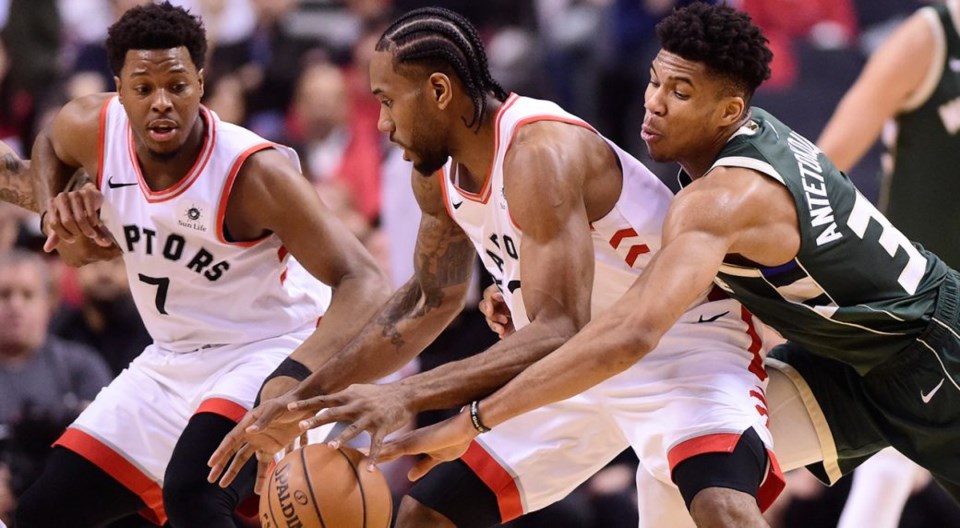 Kawhi Leonard protects the ball from Giannis Antetokounmpo.