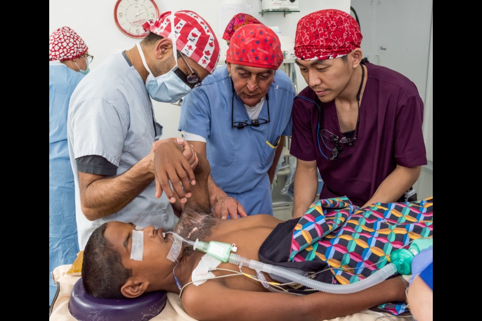 Dr Kimit Rai (centre) checks a burn victim on one of his missions