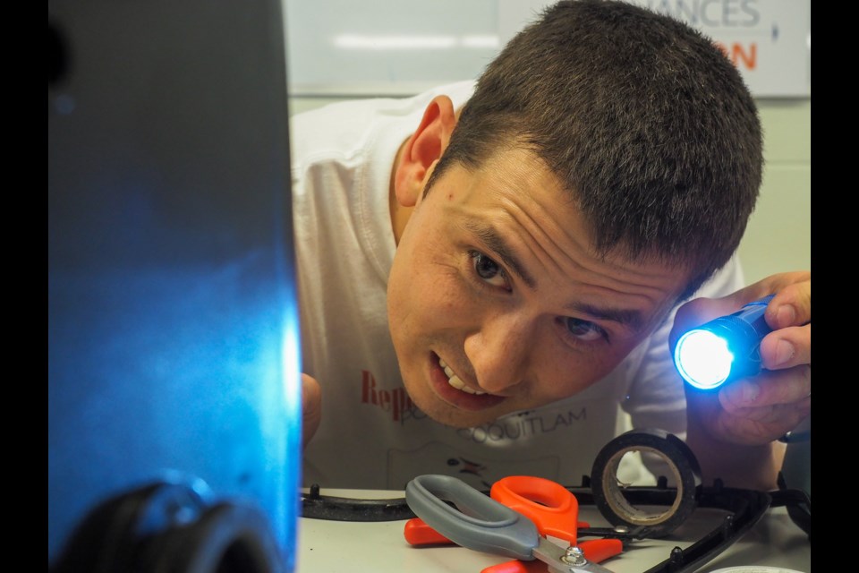 Dan Withers peers into a screw hole after soldering the guts of a automated foot massager. An electrical engineer, Withers regularly volunteers at similar events across the Lower Mainland. “I really enjoy it," he said.