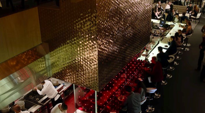 The camera pans down that shimmering wall in the bar/kitchen area of Vancouver’s Glowbal. Screenshot