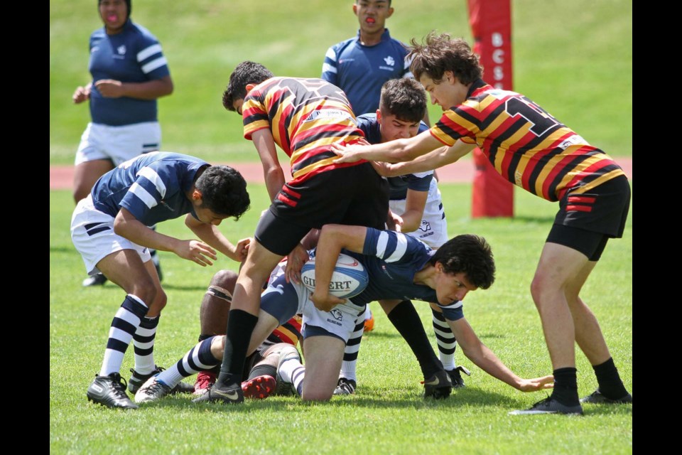 Byrne Creek Bulldogs’ Muhammad Atasoy, with the ball, takes the low route through some Sir Charles Tupper tacklers while teammates Alex and Noah Flores, Carlos Francia and Rasullah Karimulallah provide support during Saturday’s AA Tier 2 senior boys rugby championship final at Abbotsford’s Rotary Stadium.