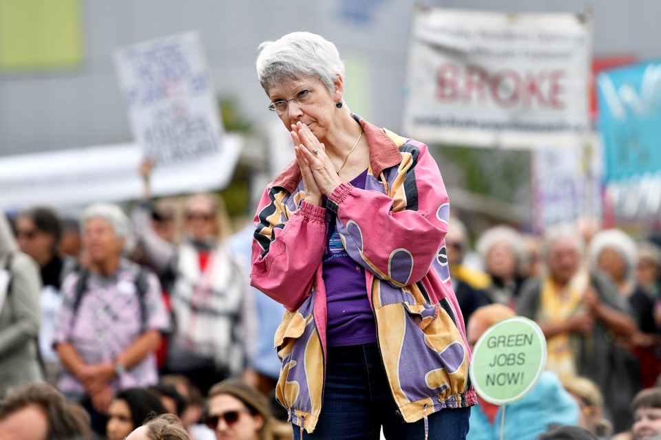 Penny Oyama of Burnaby reacts to Svend Robinson's speech at the rally in opposition to the Trans Mountain pipeline at Creekside Park in Vancouver. Photograph by JENNIFER GAUTHIER