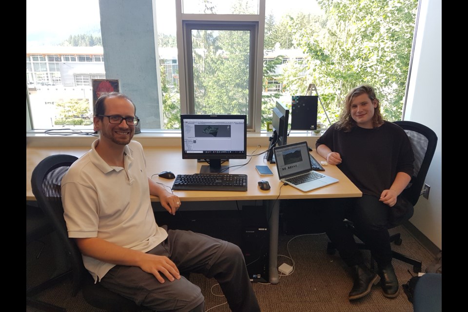 Rob Newell (left) and one of his research assistants, Nate McCarthy (right), working in their Quest University office.