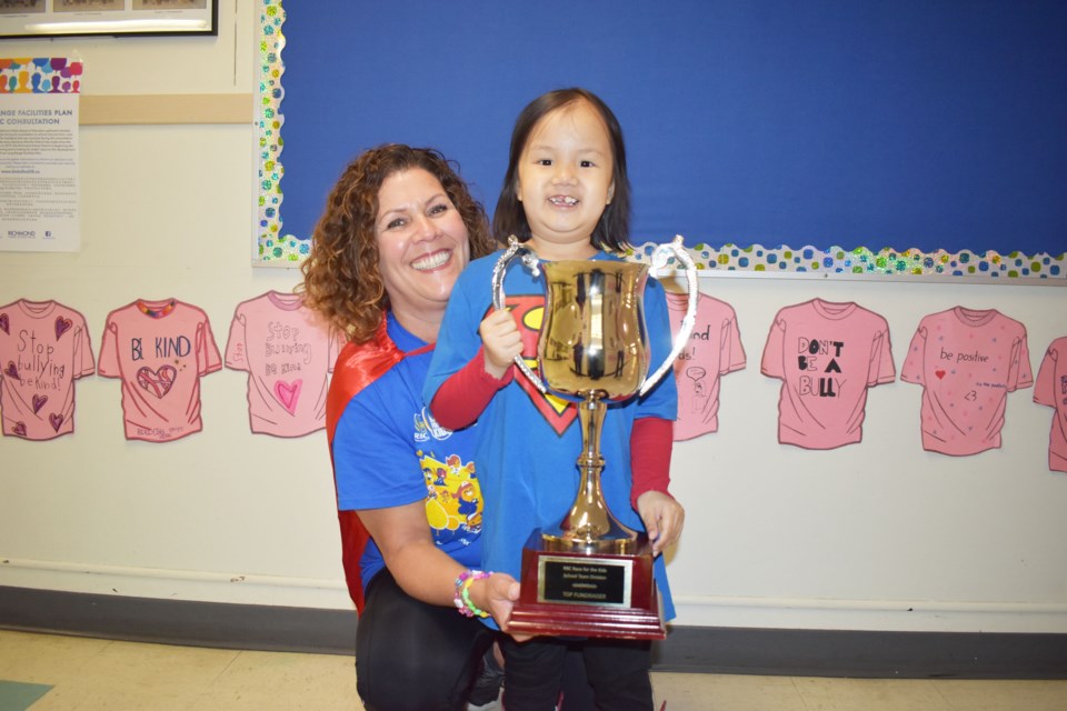 Michele Melanidis (left) and Kelsey held the trophy from Race for Kids event.