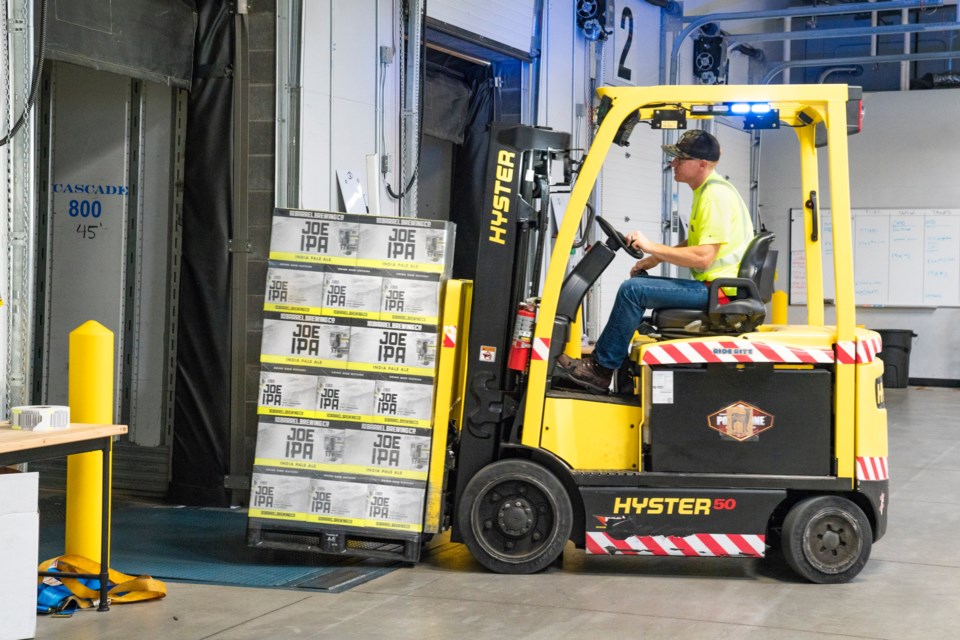 A worker loads beer on a truck