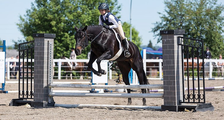 Anja Sales and Lacy Chicolitta clear the obstacle on Saturday morning at the Prince George Agriplex while competing in North Central B.C. Cadora’s annual Dressage and Hunter Jumper competition. Citizen Photo by James Doyle