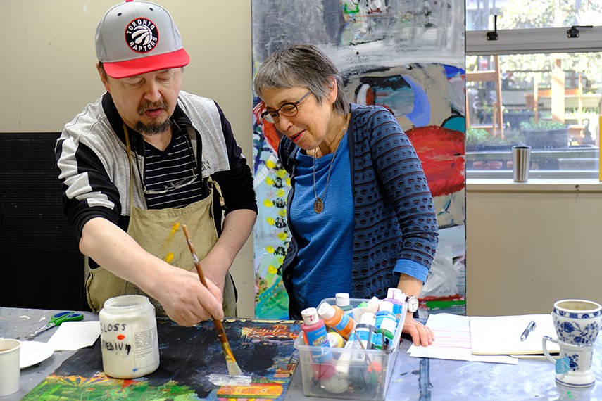 Ken Korhoren (left), member artist at Coast Mental Health, talks with Rae Maté volunteer in the Coast Mental Health Art Room.