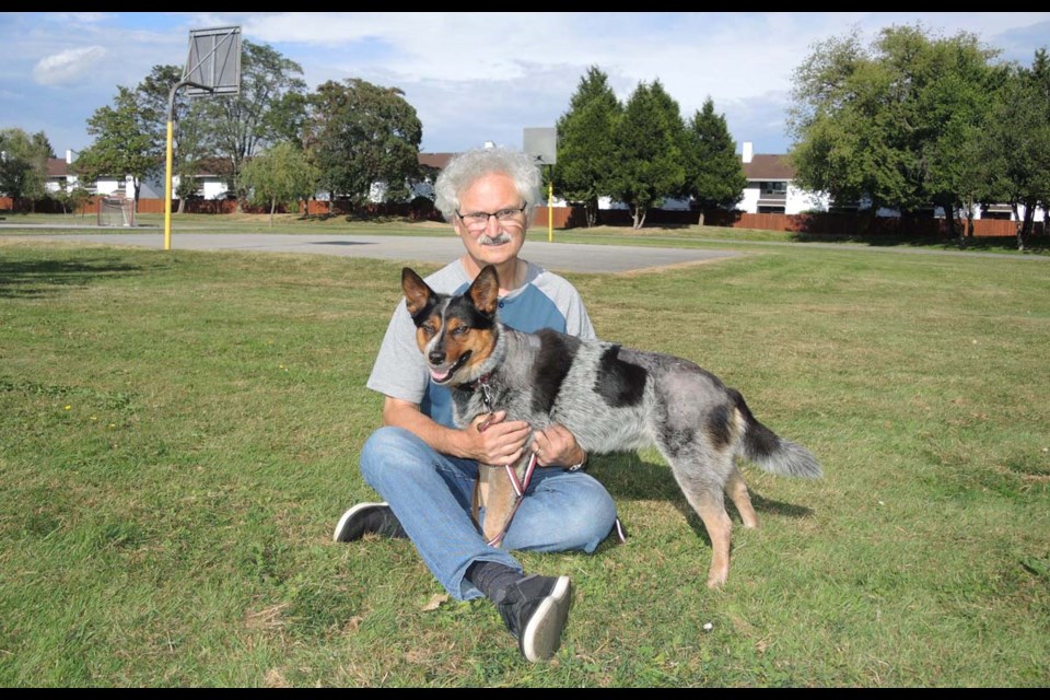 Ivano Bicego comforts his Australian cattle dog Kelli, near the scene at Walter Lee elementary, where she was attacked Tuesday night by two pit-bull type dogs. Alan Campbell photo