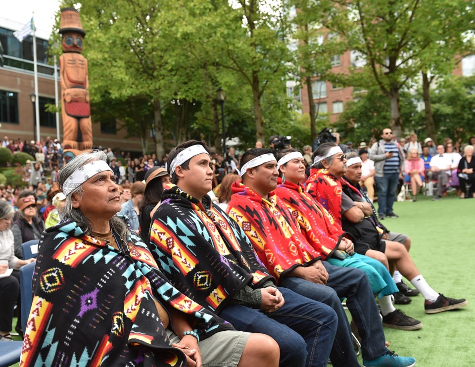 Carvers Xwalacktun and his son James Harry, Chris and Chrystal Sparrow, and William Dan listen to sp