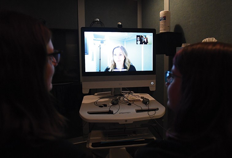 Lily Palmer and her mother, Andrea, speak with audiologist Raegan Bergstrom via telehealth video conferencing at University Hospital of Northern British Columbia on Thursday.