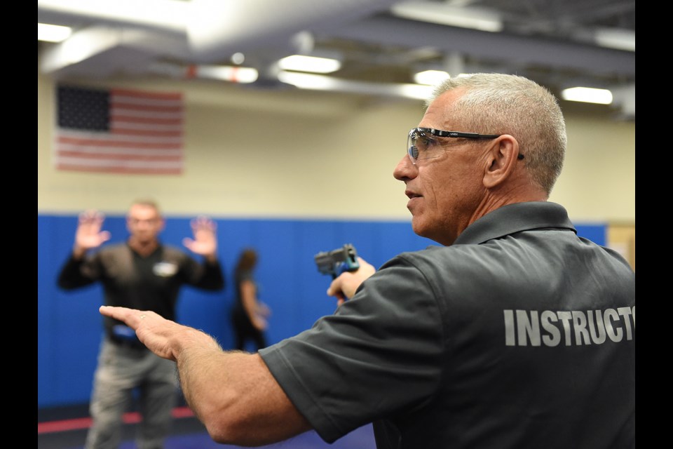 Retired VPD Sgt. Clive Milligan takes reporters through how an officers might deal with an armed suspect at a SkyTrain station. On Friday, Vancouver Police Department held a media day at the department's Tactical Training Centre. Photo Dan Toulgoet