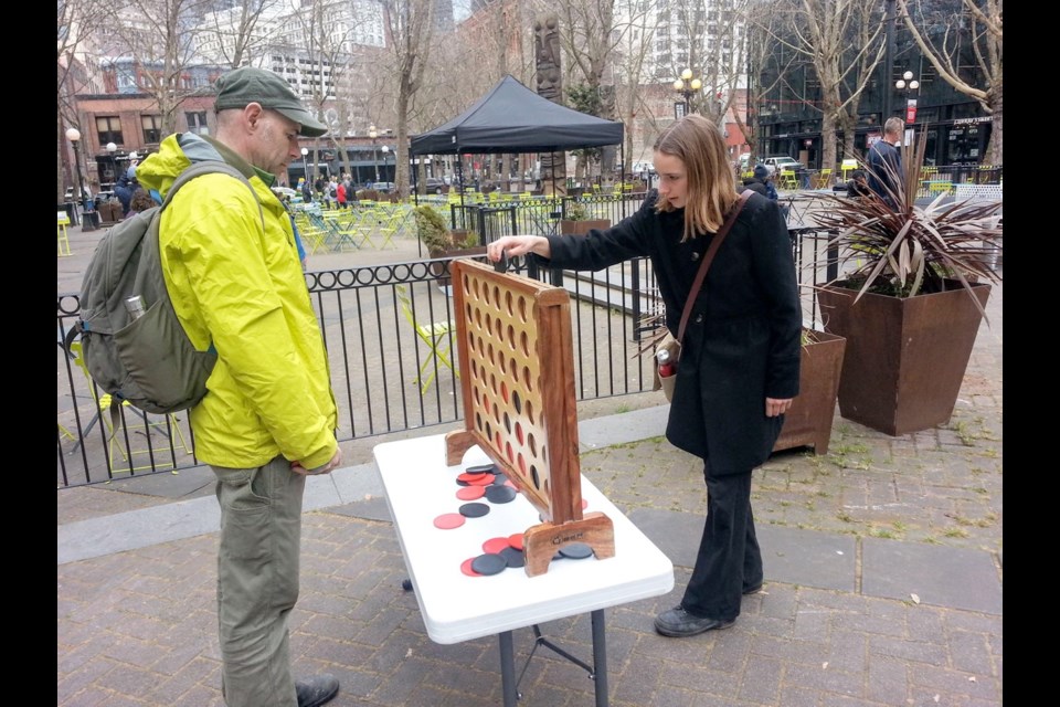 Playing Connect Four at Occidental Square in Seattle, where a renewal effort began in 2016.