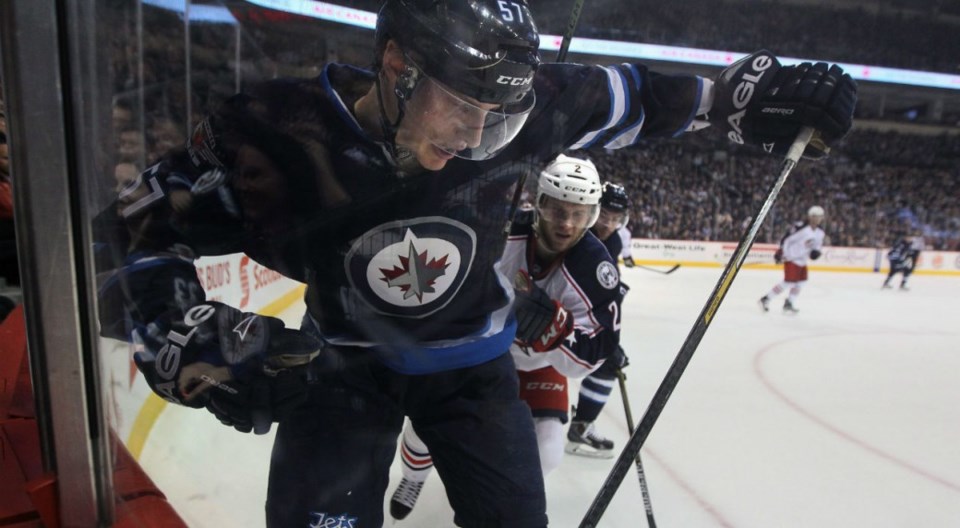 Tyler Myers battles for the puck in the corner for the Winnipeg Jets.