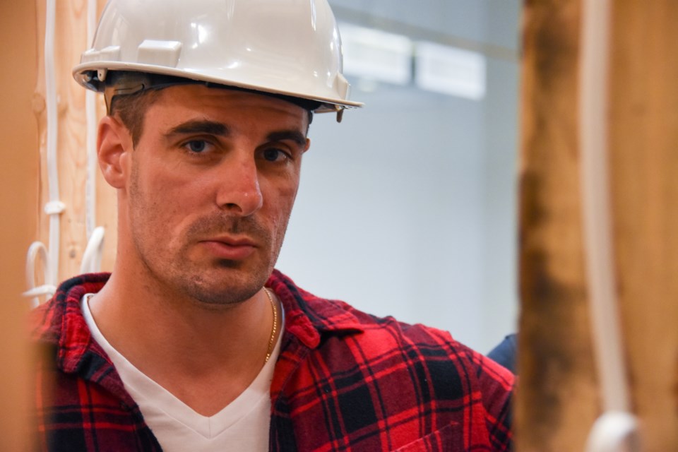 Jared Turenne, 35, waits for the results of a test after wiring up a mock condominium
