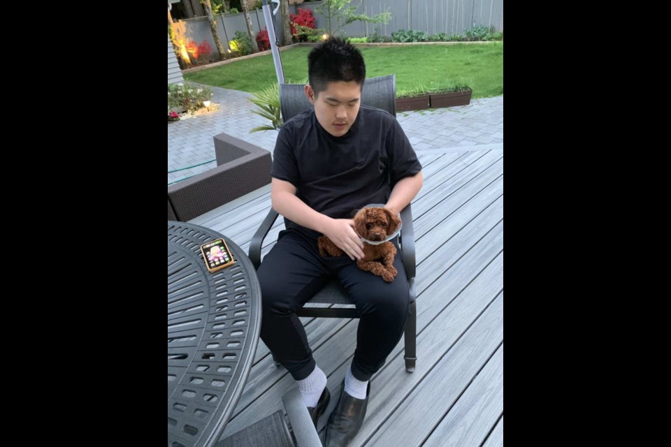 Jason Guo with his new pet Mochi pose for a photo. After losing Dora, Jason's family friends gave them a new dog to help them forget painful memories.