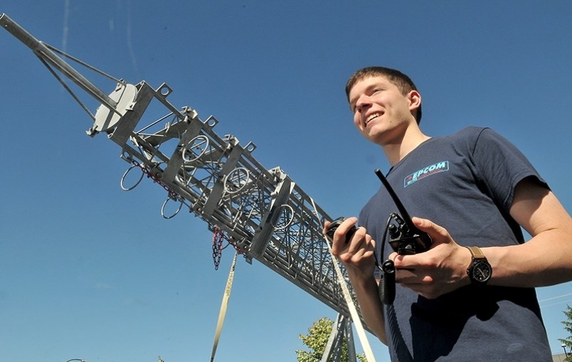 Local radio enthusiast Tyler Cristiano stands next to a Cellular on Wheels, or COW, during an annual