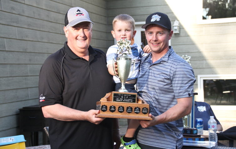 Lee Hartman hands Adam Horst the award for Flyers Playoff and Coy Cup MVP, as Horst's son Callum joins them for the photo.