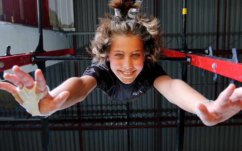 Danika Michelsen hangs from a high bar at the Momentum Ninja Training Centre in Port Coquitlam. She's one of 36 athletes from the gym who've qualified to compete at the Ultimate Ninja Athletic Association world championships in Minnesota in July.