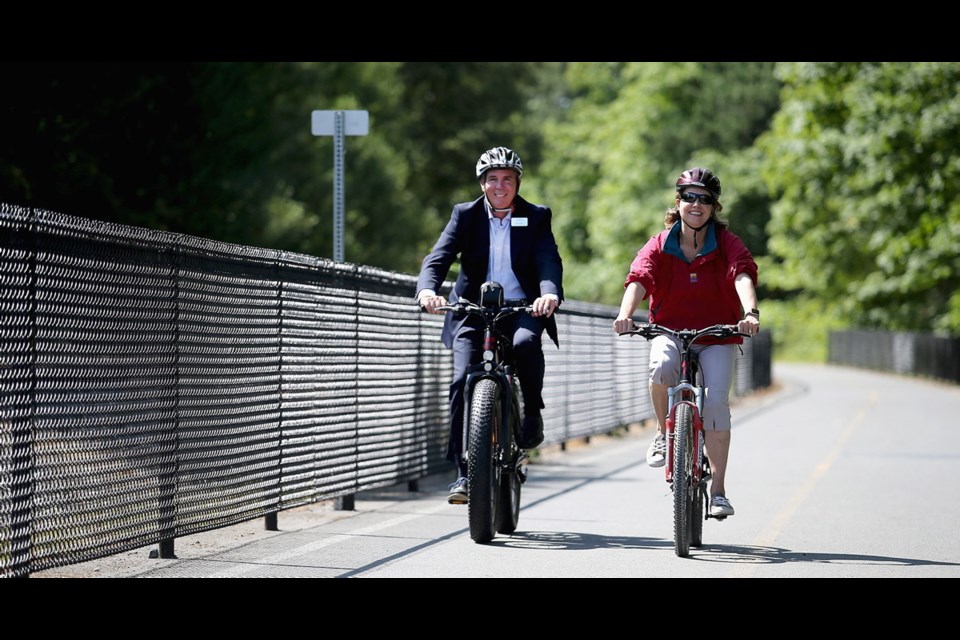 Bob Lapham, chief administrative officer for the Capital Regional District, and Mitzi Dean, MLA for Esquimalt-Metchosin, take a ride along the E&N Rail Trail at Portage Park in View Royal.