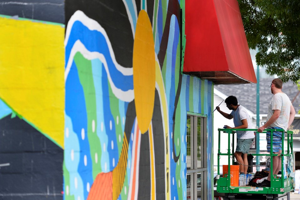 Sonny Green paints as boyfriend Jarod Kingston-Brown looks on. This year's Vancouver Mural Festival starts Thursday and will feature 25 new murals. Photo Jennifer Gauthier