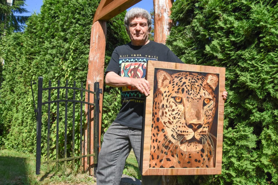 Fred Soofi at his home in Port Moody with a piece of art made by Saeed Malekpour. Soofi was part of