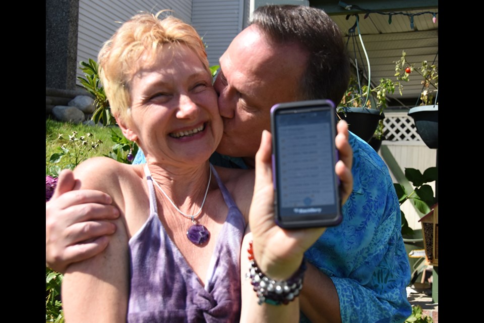 Holly Bruce-Steiner holds her phone containing the more than 3,000 messages she received from around the world after her husband, Larry Steiner, circulated a flyer in Coquitlam asking people to text his wife on their 30th anniversary, Aug. 2, saying "Larry loves you."