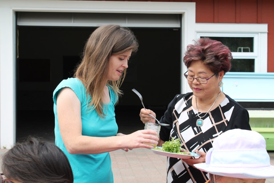 Alice Wong (right) trying the farm's fresh produce with Sarah Drewery (left).