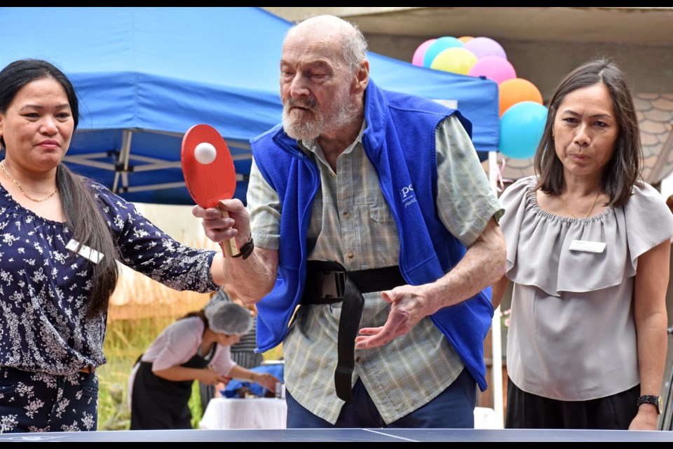 Rudy Nobauer serves against his daughter during Normanna a ping pong match at Normanna seniors home.