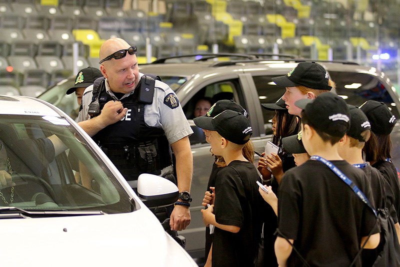 MARIO BARTEL/THE TRI-CITY NEWS
Cst. Justin Leleux, of Coquitlam RCMP, demonstrates the perils of standing too close to a car during a simulated traffic stop at Junior Mounties camp, last Wednesday at the Poirier Sport and Leisure Complex.